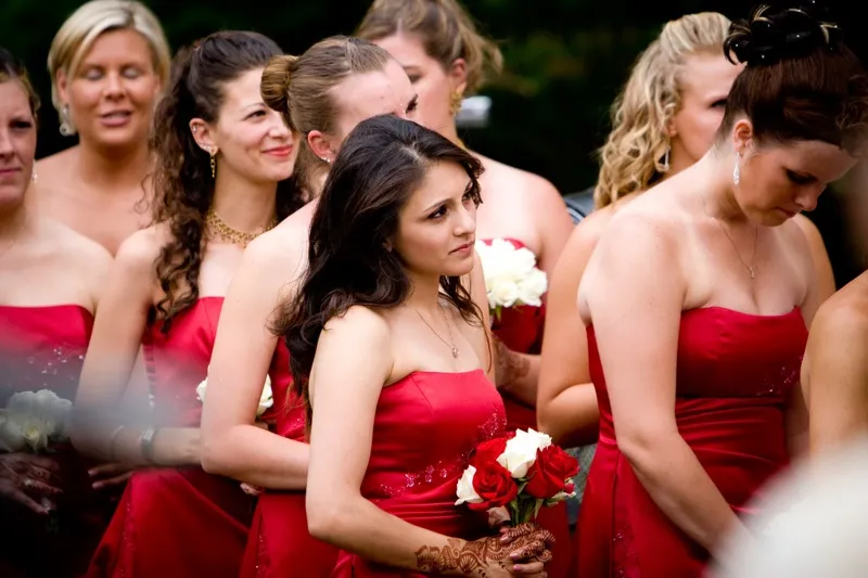 Bridesmaids attending destination wedding ceremony in coordinated dresses
